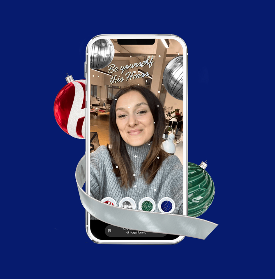 A girl smiling in a selfie using the Hogan instagram filter with Christmas baubles, snow and the message 